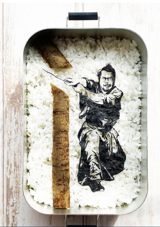 ציירת מוכשרת מהירושימה, יפן, מצייר דמויות מוכרות על אורז לבן.