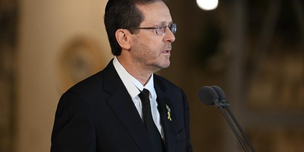 a man in a suit and tie speaking into a microphone