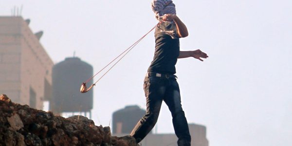 נער פלסטיני זורק אבנים אל עבר חיילי צה"ל | צילום:  Issam Rimawi/Flash90