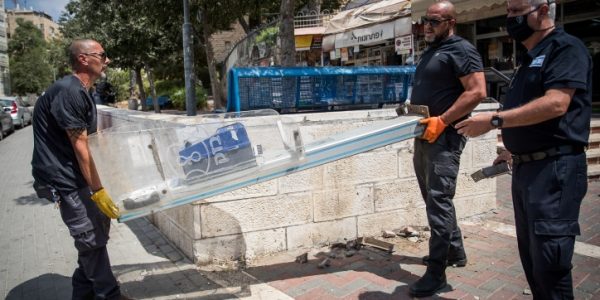 פועלים מסירים עמדה של טלפון ציבורי בירושלים לפני מספר חודשים ///  Yonatan Sindel/Flash90