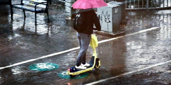 נוסע על קורקינט חשמלי ביום גשום ברחובות תל אביב / צילום: Avshalom Sassoni/Flash90