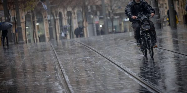 People carry umbrellas as they protect themselves from the rain, in jerusalem. January 23, 2024. Photo by Chaim Goldberg/FLASH90 *** Local Caption *** 
מזג אוויר
חורף
ירושלים
גשם