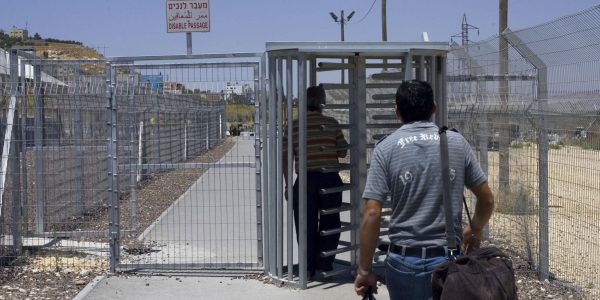 פועלים פלסטיניים עוברים במחסום לקראת כניסתם לישראל | צילום: Olivier Fitoussi /FLASH90