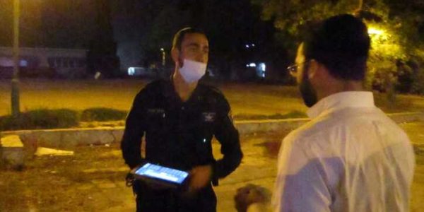שוטר נותן דו"ח במתחם הישיבה